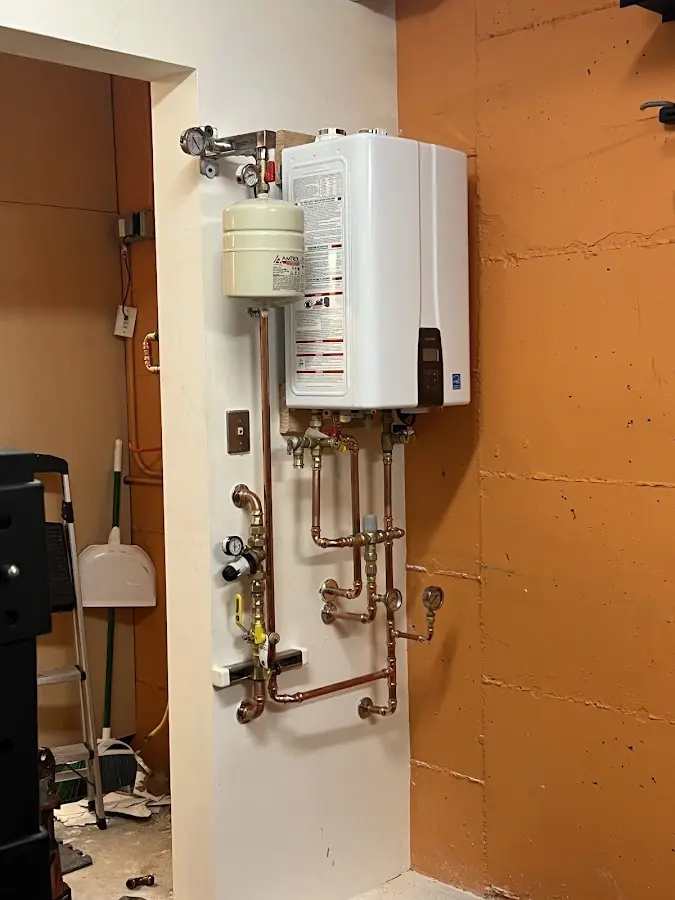 Plumbing technician inspecting water heater connections in Adel